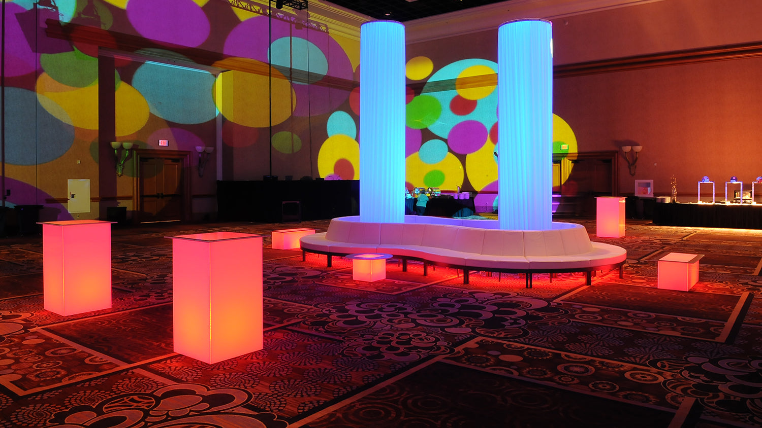 Swirled acrylic dining tables with a purple light in a golden room