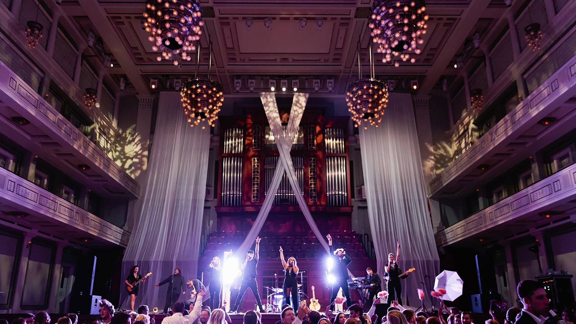 Stunning ceiling showing rental drapes and chandeliers for a music performance.