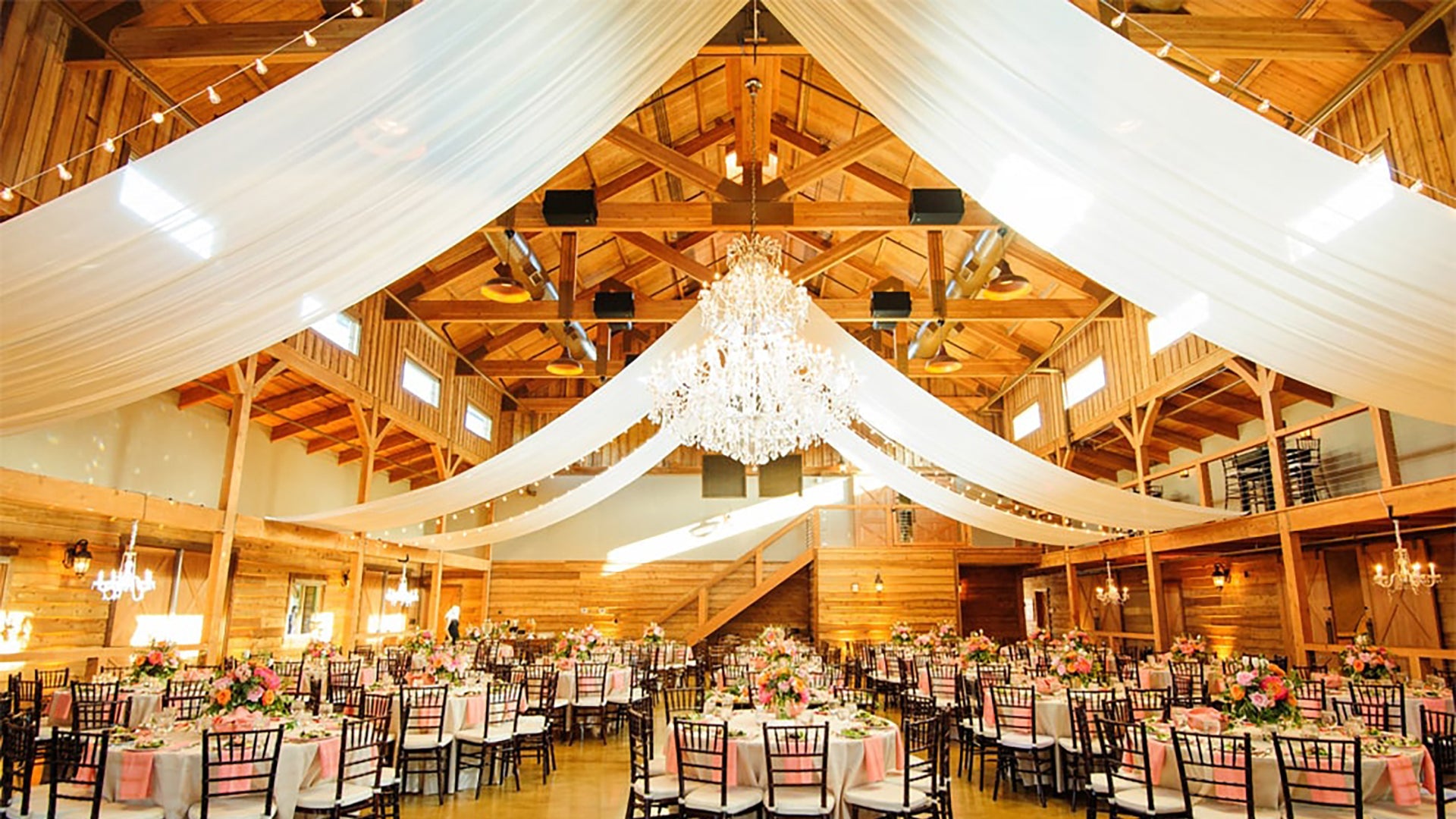 A stunning ceiling for a wedding with drape and chandeliers.