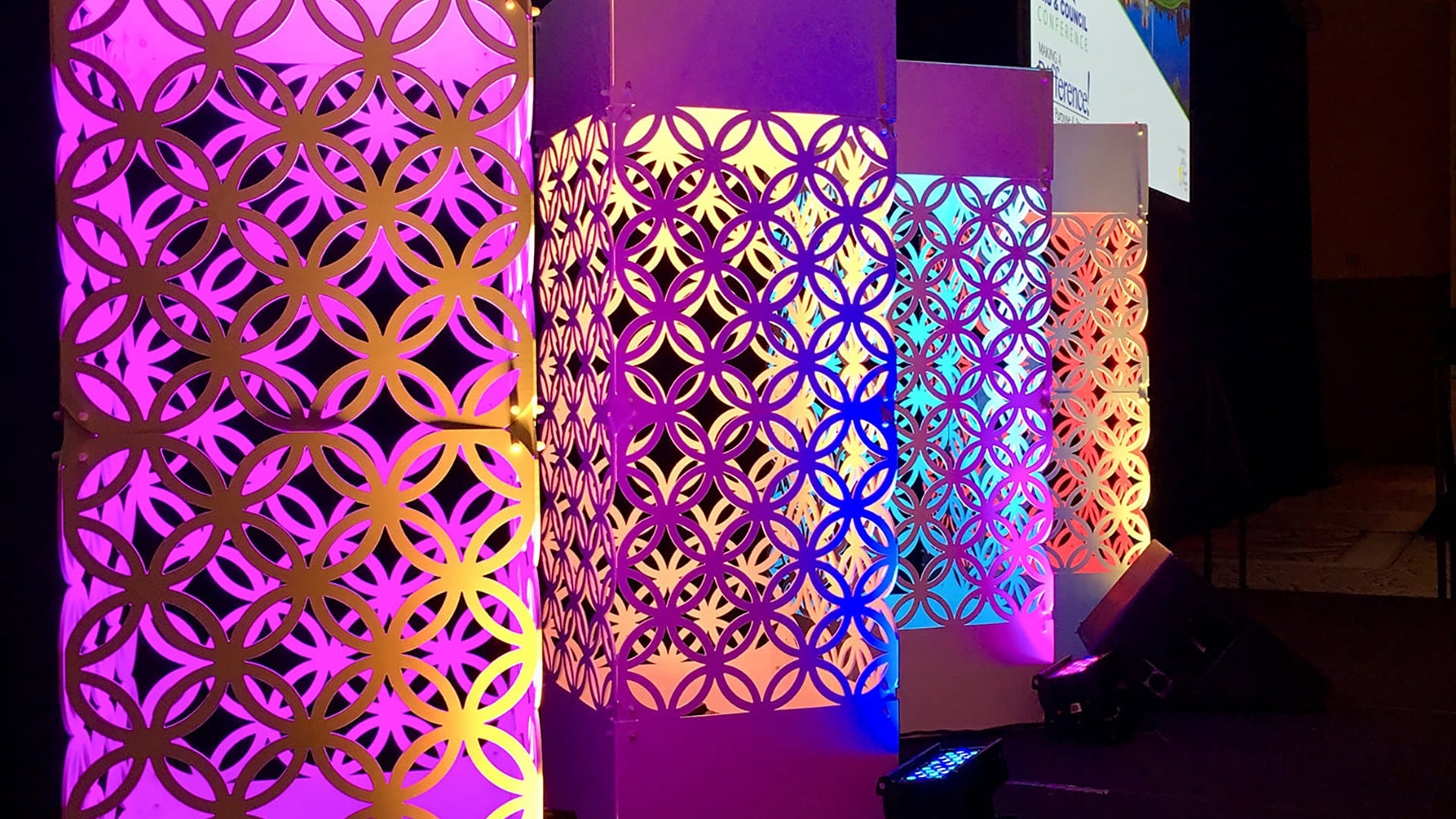 GeoSeries towers lit in vivid purple, yellow, and blue at a trade show